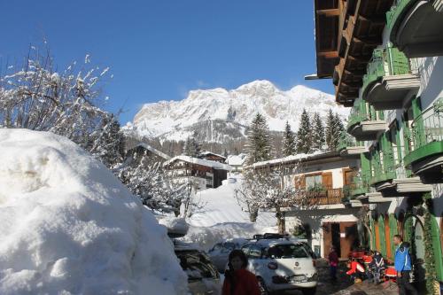 a snow covered street with a mountain in the background at Hotel Pontechiesa in Cortina dʼAmpezzo