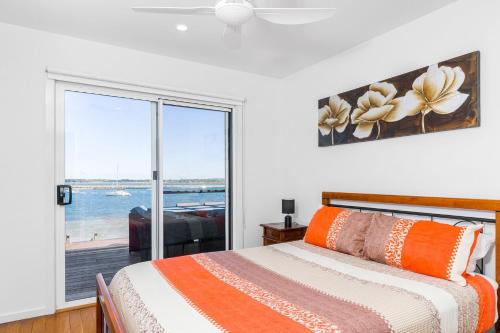 a bedroom with a bed and a view of the ocean at Omaroo Prestige Waterfront in Iluka