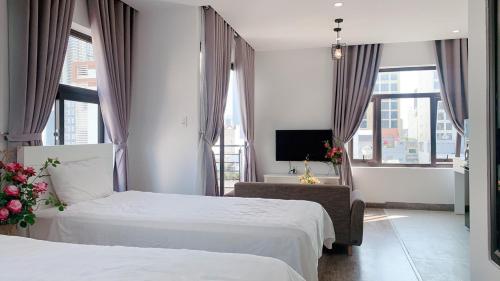 a hotel room with two beds and a tv at 5A - Pool seaview Blue Sea Apartment in Da Nang