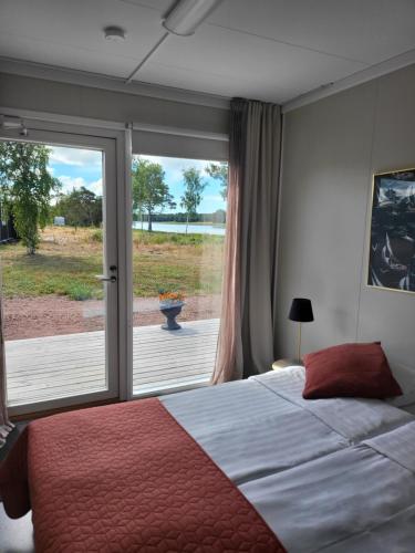 1 dormitorio con 1 cama y puerta corredera de cristal en Eckerö Camping & Stugor, en Eckerö