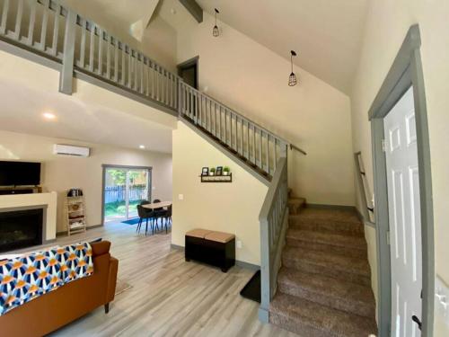 sala de estar amplia con escalera y sofá en NEW Modern Cabin! 5mi to Mt Rainier National Park! Hot Tub & Wifi, en Ashford