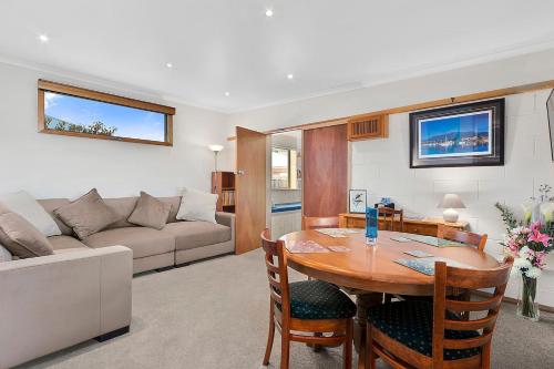 a living room with a table and a couch at Forty South Cottage - A Secluded Waterside Getaway in Lindisfarne