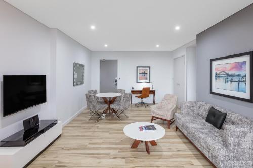 a living room with a couch and a table at Meriton Suites Church Street, Parramatta in Sydney