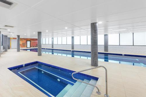 an indoor pool with a swimming pool at Meriton Suites Church Street, Parramatta in Sydney