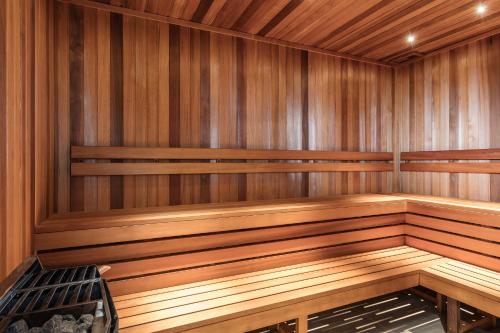 a wooden sauna with a wooden bench in it at Meriton Suites Church Street, Parramatta in Sydney