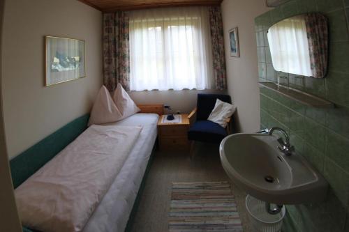 a small room with a bed and a sink at Haus Ganschitter in Wagrain