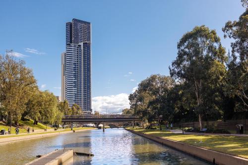 a river in a city with a tall building at Meriton Suites Church Street, Parramatta in Sydney