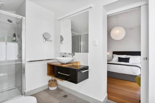 a bathroom with a sink and a shower and a bed at Pillinger Street - luxurious renovated home in Hobart