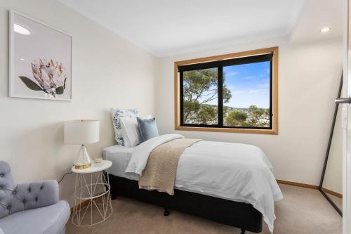 Habitación blanca con cama y ventana en Panoramic water views with stunning interiors en Bellerive