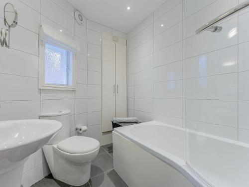 Baño blanco con aseo y lavamanos en Flat 4A, en Chester