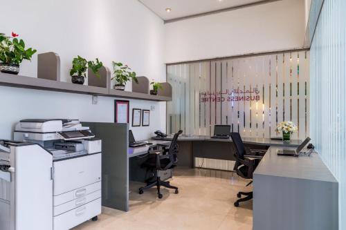 an office with two desks and chairs and plants at Millennium Plaza Downtown Suites in Dubai