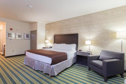a hotel room with a bed and a chair at Holiday Inn Texarkana Arkansas Convention Center by IHG in Texarkana