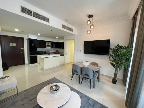 a living room with a table and a kitchen at Luxury living & Fully-furnished 3 Bedroom Apartment next to Dubai Mall in Dubai