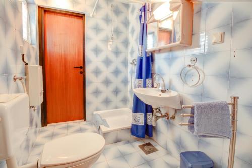 uma casa de banho com um WC branco e um lavatório. em Apartments by the sea Vrboska (Hvar) - 4025 em Vrboska