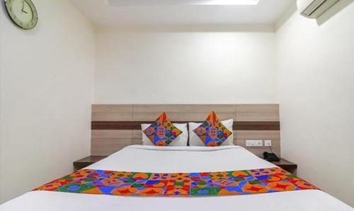 a bedroom with a bed with a colorful blanket on it at FabHotel Pride Inn Financia in Hyderabad