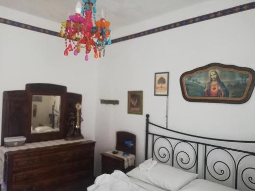 a bedroom with a bed and a mirror and a chandelier at Casa caratteristica nel Parco del Cilento in Cuccaro Vetere