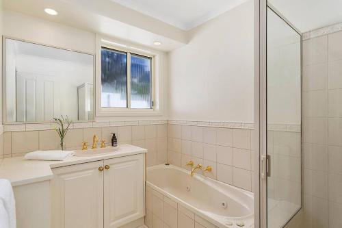 a bathroom with a tub and a sink and a shower at Scenic Sandy Bay Home with Stylish Interior in Sandy Bay