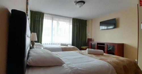 Habitación de hotel con 2 camas y ventana en Hodu Hospedaje, en Quito