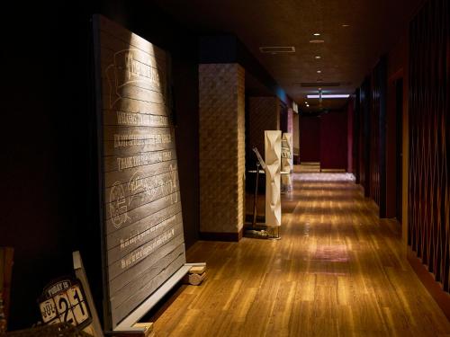 a hallway of a building with wooden floors and walls at Hotel Flags Kuju Kusima in Sasebo