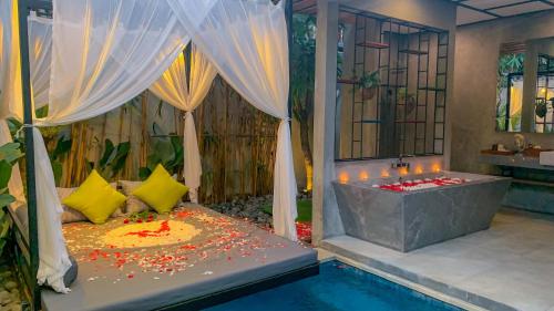 a bedroom with a tub next to a pool at Vinna Villa Seminyak in Kerobokan