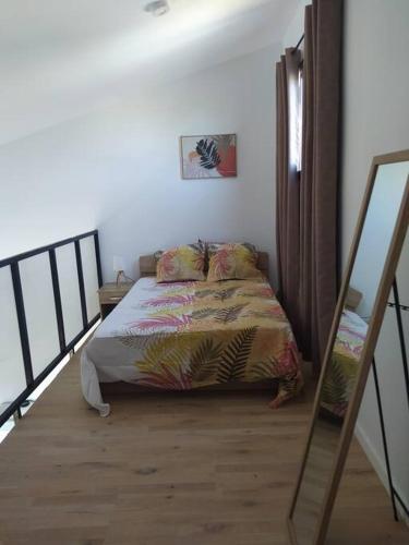 a bedroom with a bed and a staircase with a mirror at Le coin paisible in Saint-Louis