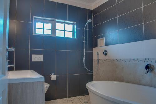 a bathroom with a tub and a toilet and a sink at ilanda Guest House in White River