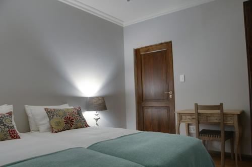 a bedroom with a bed and a wooden door at ilanda Guest House in White River