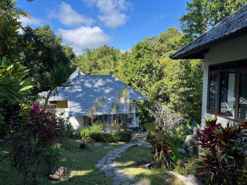 uma casa com um telhado azul e um jardim em Balian Bliss Retreat Bungalow & Villas em Balian