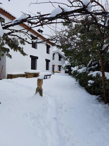 a fire hydrant covered in snow in front of a house at Casas rurales Camaretas in Yeste