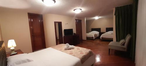 a hotel room with two beds and a mirror at Hodu Hospedaje in Quito