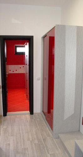 a hallway with two doors and a red floor at Incanto Family Hotel in Sevlievo