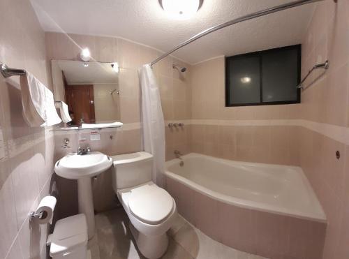 een badkamer met een toilet, een bad en een wastafel bij Hodu Hospedaje in Quito