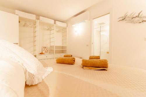 una camera da letto bianca con 2 cuscini pieghevoli su un letto di House On The Sea Porto Rotondo a Porto Rotondo
