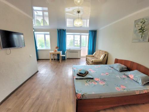 a bedroom with a bed and a living room at 1 комн. Апартаменты на Абая 122 in Kokshetau