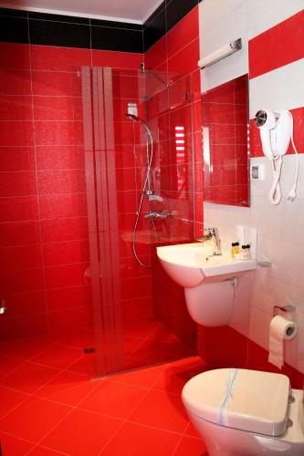 a red bathroom with a toilet and a sink at Incanto Family Hotel in Sevlievo