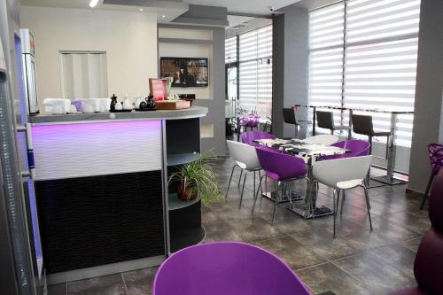 een bar met paarse stoelen en een tafel in een kamer bij Incanto Family Hotel in Sevlievo