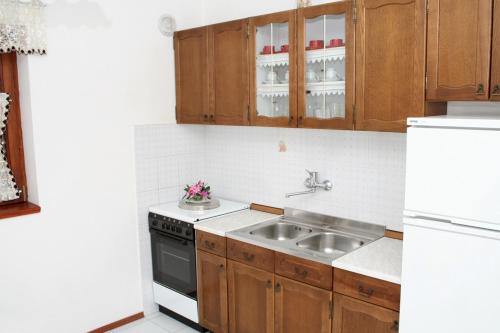 a kitchen with a sink and a white refrigerator at Apartments by the sea Mandre, Pag - 4123 in Kolan