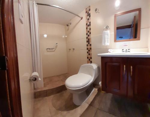 a bathroom with a toilet and a sink and a shower at Hodu Hospedaje in Quito