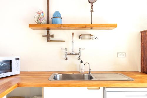 a kitchen with a sink and a microwave at The Villino at Cypress Ridge Estate in Onetangi