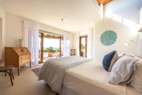 a bedroom with a bed and a desk and a window at The Villino at Cypress Ridge Estate in Onetangi