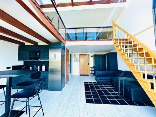a kitchen and living room with a staircase in a house at Sea & Sunset View Apartment In Palanga in Palanga