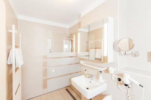 a white bathroom with a sink and a mirror at Fabelhafte Wohnungen in der Altstadt in Heidelberg