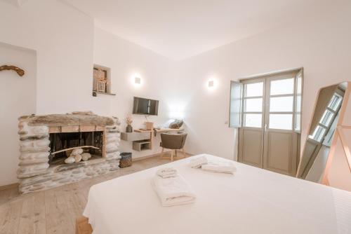 a living room with a stone fireplace and a table at Alika Resort in Álika
