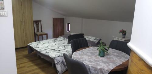 a room with a table and a bed and a table and chairs at Attic Ben Gurion 42 in Haifa