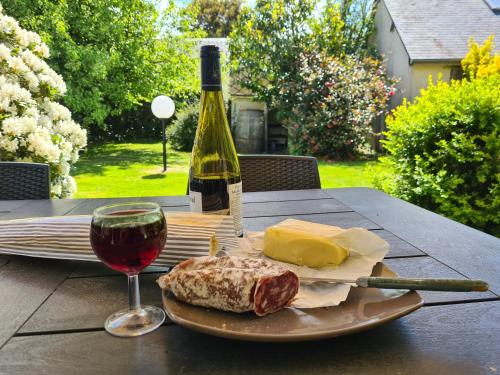 un plato de queso y una copa de vino en una mesa en La Poterie, A Vendre, en Étretat
