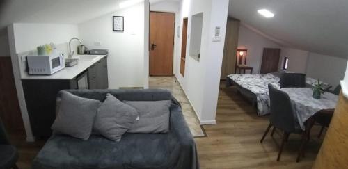 een woonkamer met een bank en een keuken bij Attic Ben Gurion 42 in Haifa