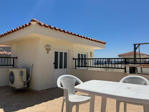 a table and chairs in front of a house at Seaview apartment with roof terrace in Kalecik