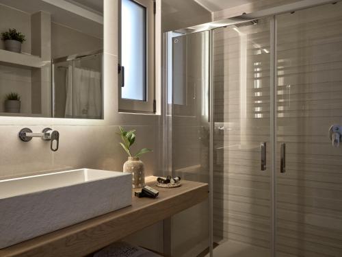 uma casa de banho com um lavatório e uma cabina de duche em vidro. em Stelle Mare Villa em Akrotiri