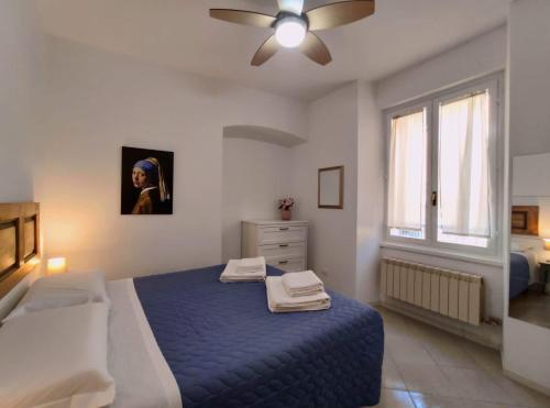 a bedroom with a blue bed and a ceiling fan at La casina al lago in Mandello del Lario