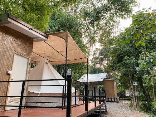 a bed with a canopy on the side of a house at NP โฮมสเตย์ นอนเต็นท์ติดแอร์ in Ban Kaeng Manao